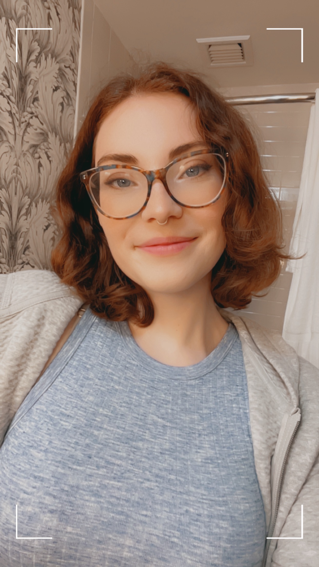 Woman in a gray shirt with glasses