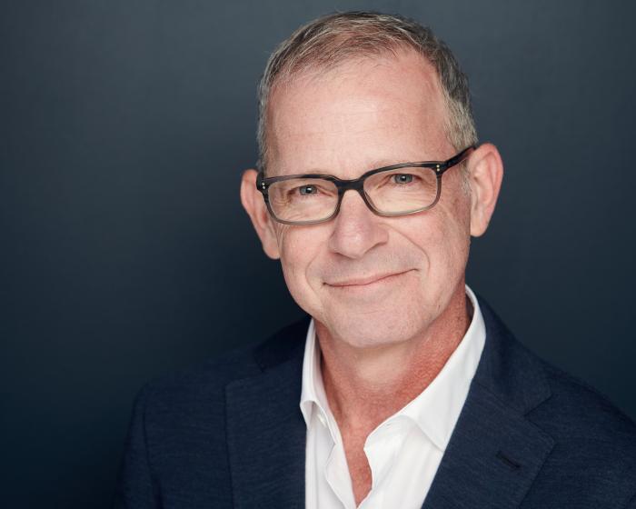 This image shows Dr. Richard Grinker. He is a white man with grey hair, no facial hair, and glasses.