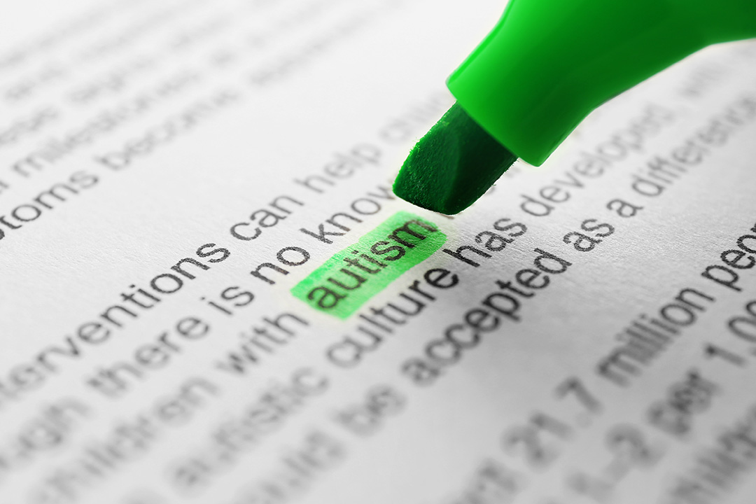 Image of a textbook page with a green highlighter on the word "autism"