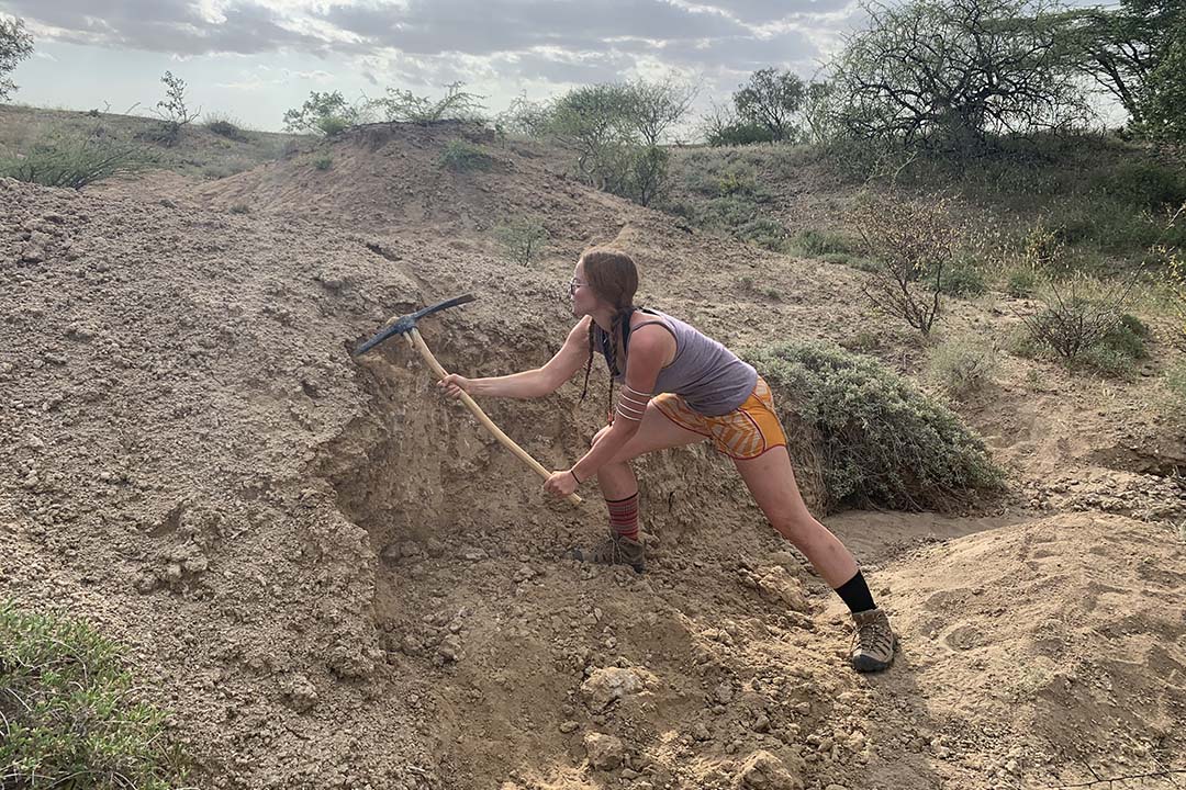 student digging with a pickaxe