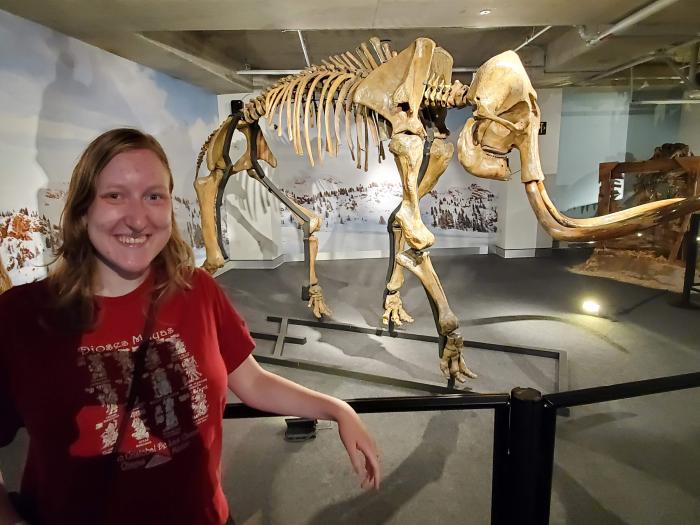 Woman in a red shirt in front of a skeleton
